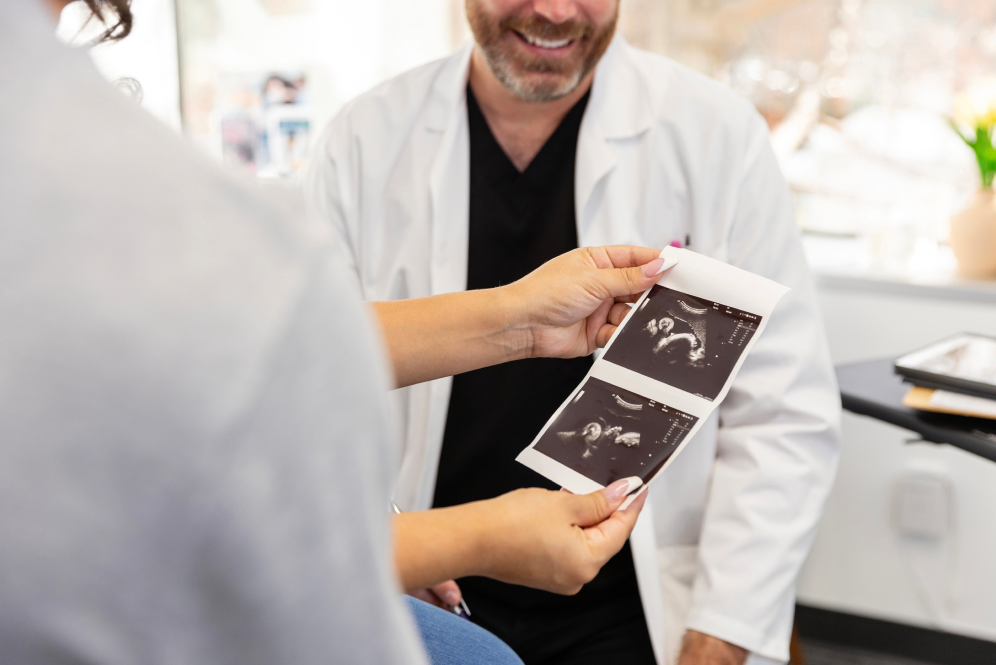 Lekarz omawiający z pacjentem zdjęcia usg płodu
