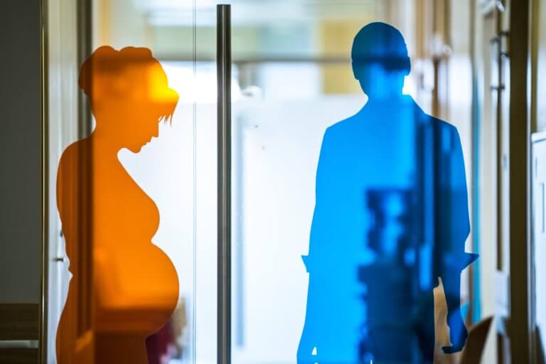 Klinika INVICTA Gdańsk - szklane drzwi z naklejonym mężczyzną i kobietą w ciąży