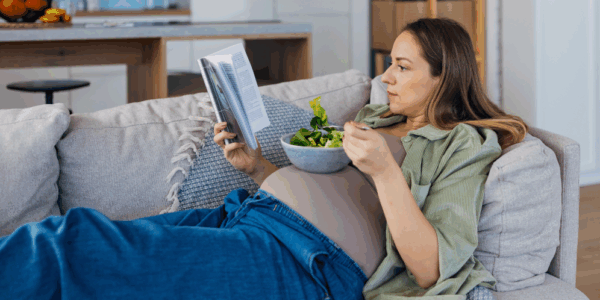 Kobieta czytająca książkę na temat optymalnej diety w ciąży