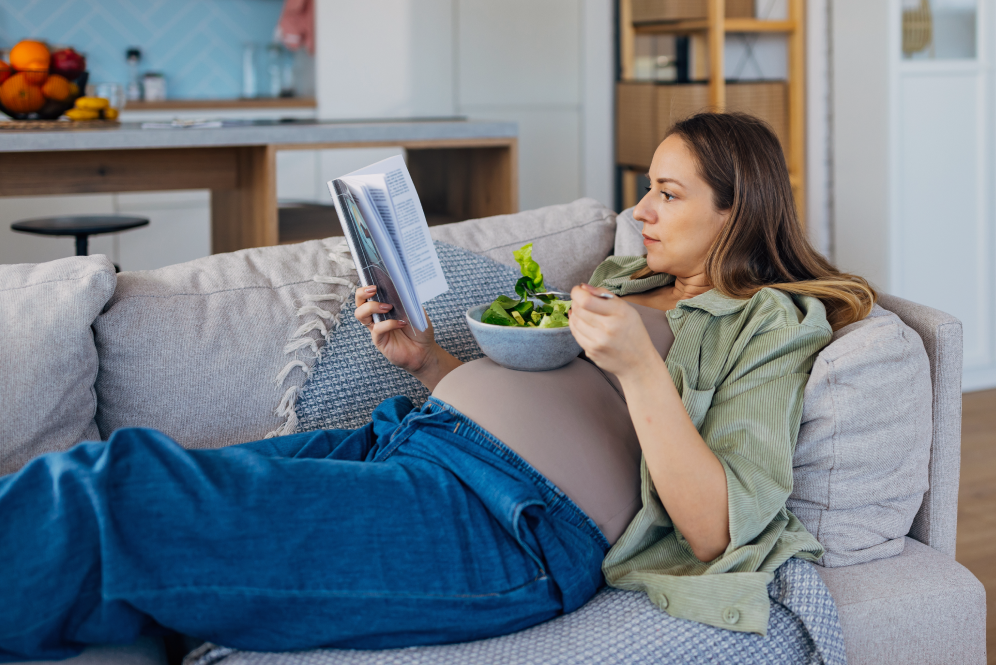 Kobieta czytająca książkę na temat optymalnej diety w ciąży