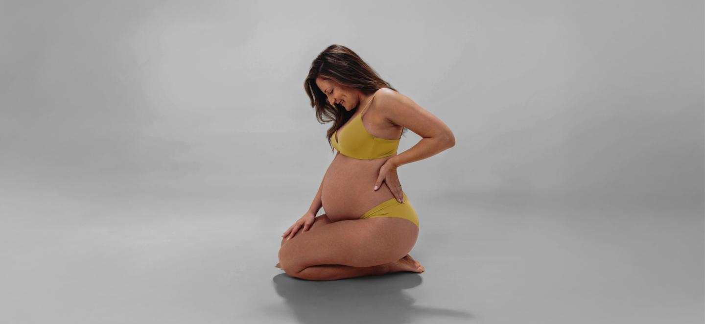 Kobieta w ciąży na szarym tle