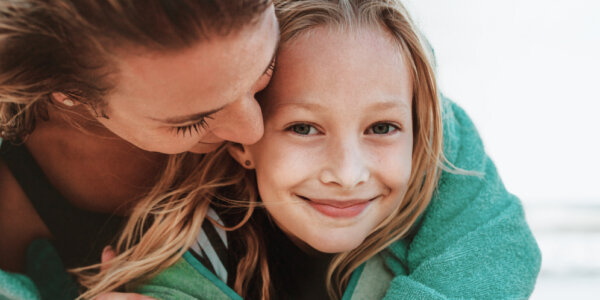 Mama przytulająca uśmiechniętą córkę – pierwsza wizyta u ginekologa dla nastolatki